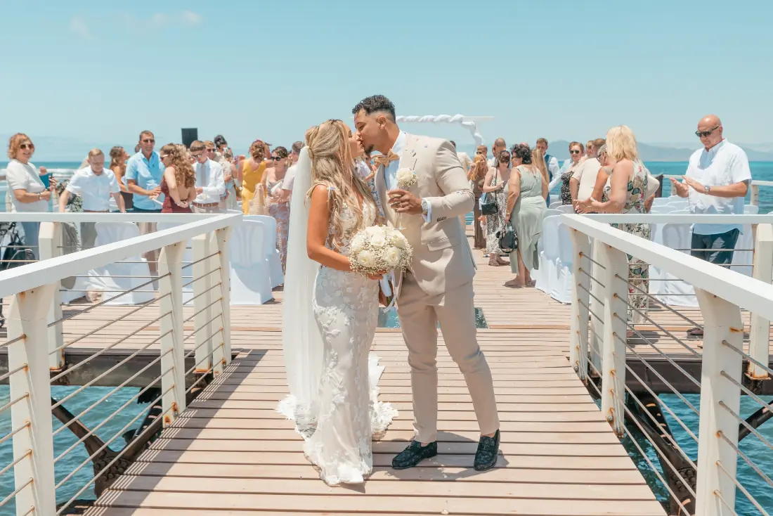 Pareja dándose un beso en la salida de la ceremonia en el hotel Bahia Secrets en Fuerteventura