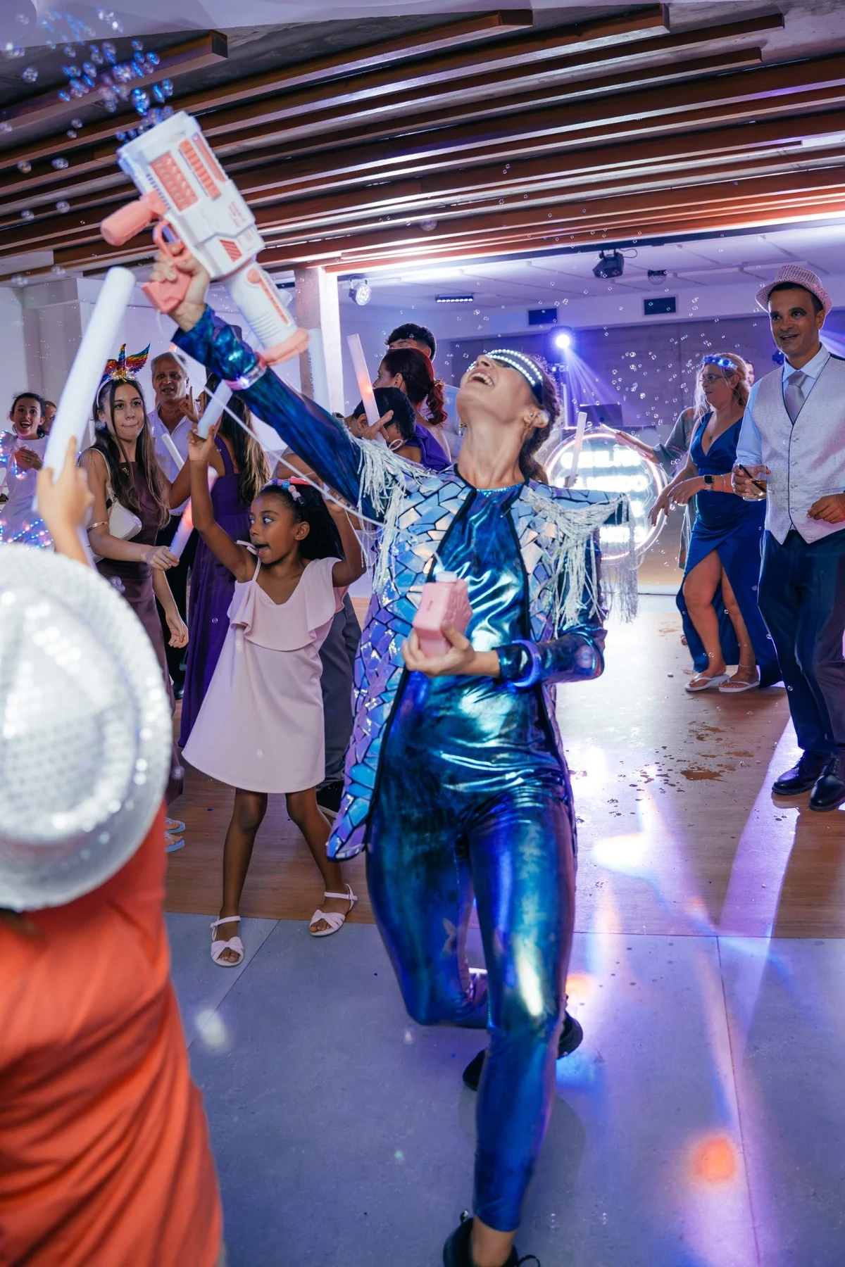 Animadora con traje holográfico lanzando burbujas en la pista