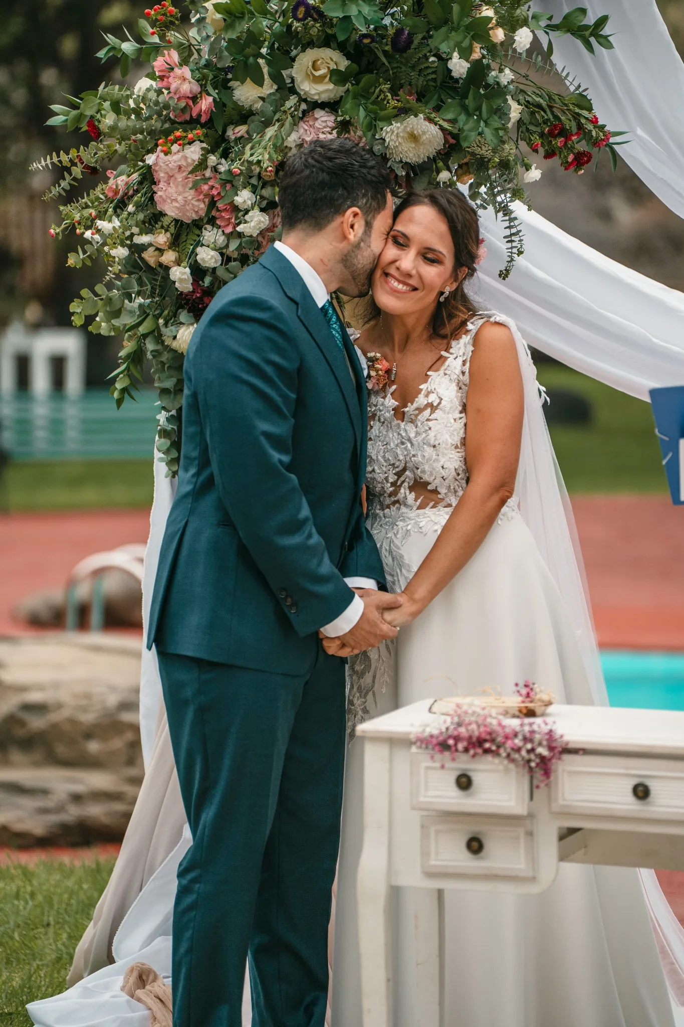 Novios besándose bajo el arco floral tras la ceremonia en Hacienda de Anzo