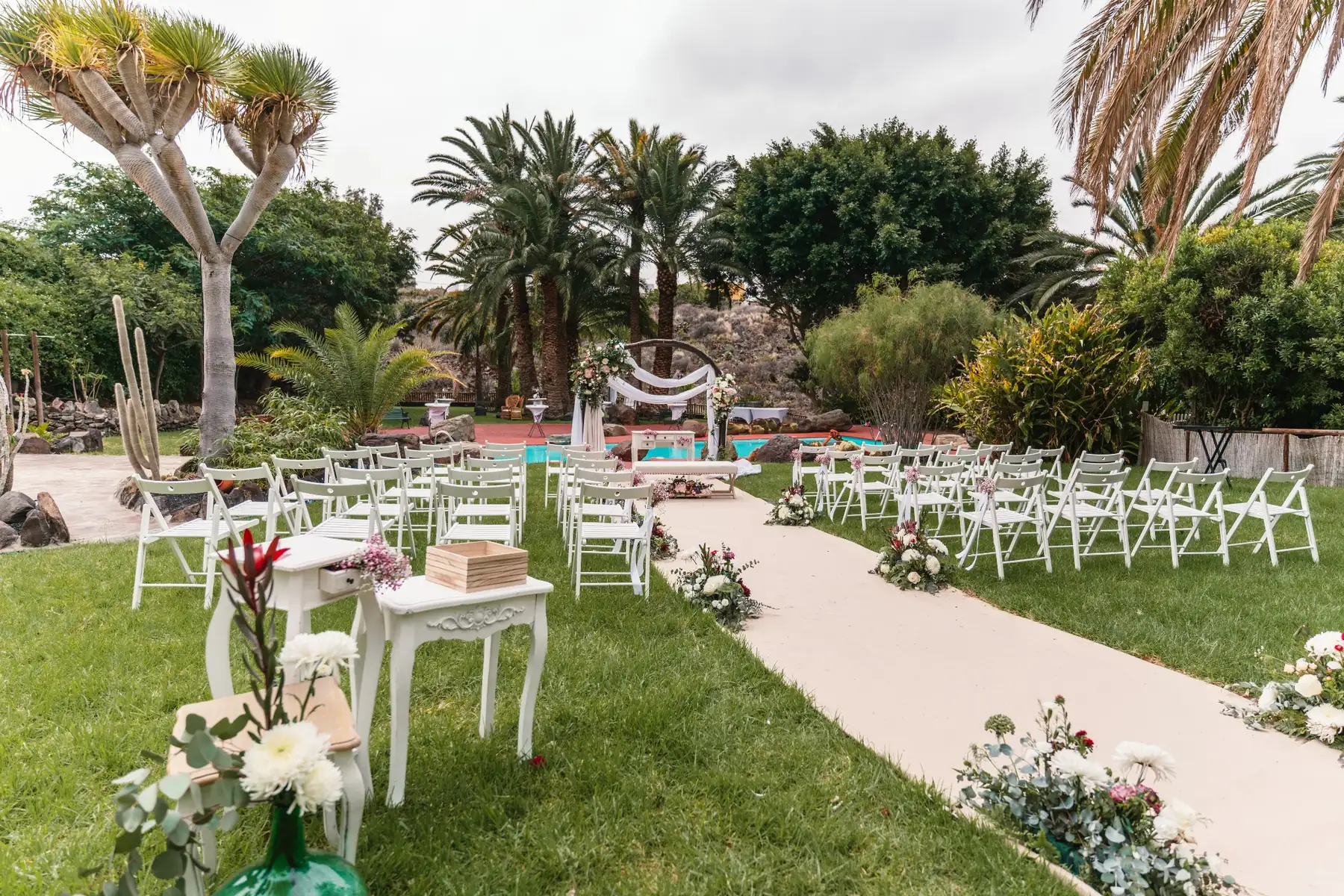 Vista general de ceremonia exterior en jardín con sillas blancas en Hacienda de Anzo, Gran Canaria