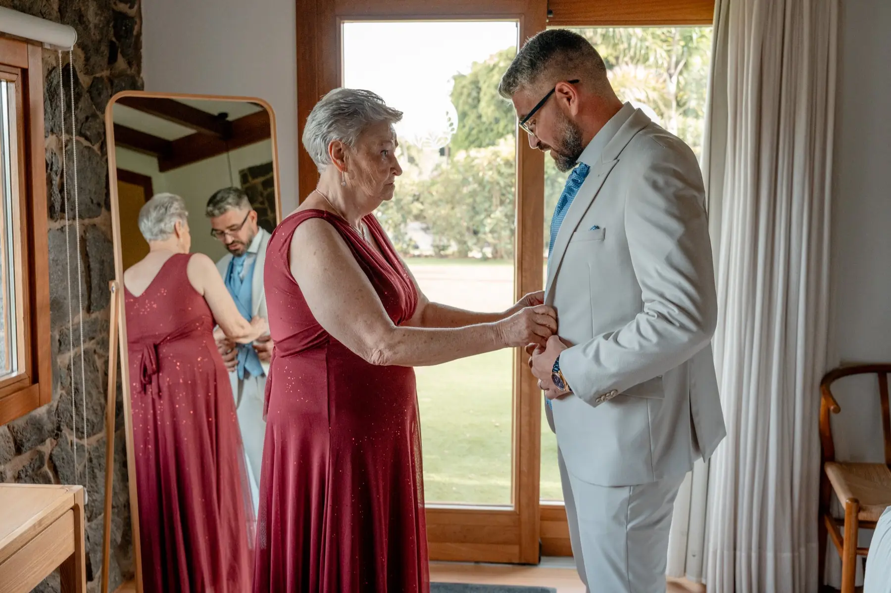 Madre ayudando al novio a vestirse