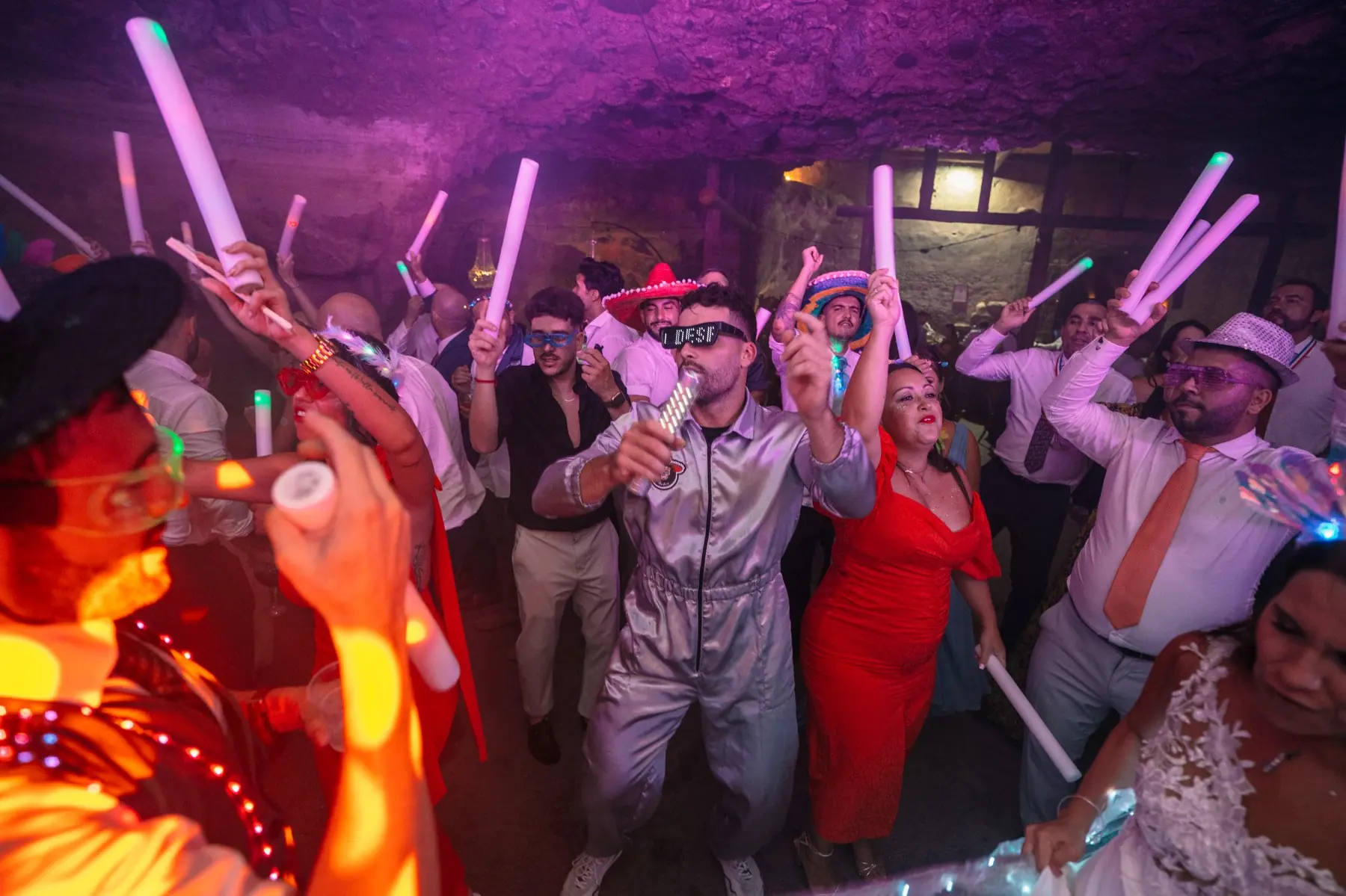 Multitud de invitados en la pista de baile iluminada en la cueva de Hacienda de Anzo, Gran Canaria