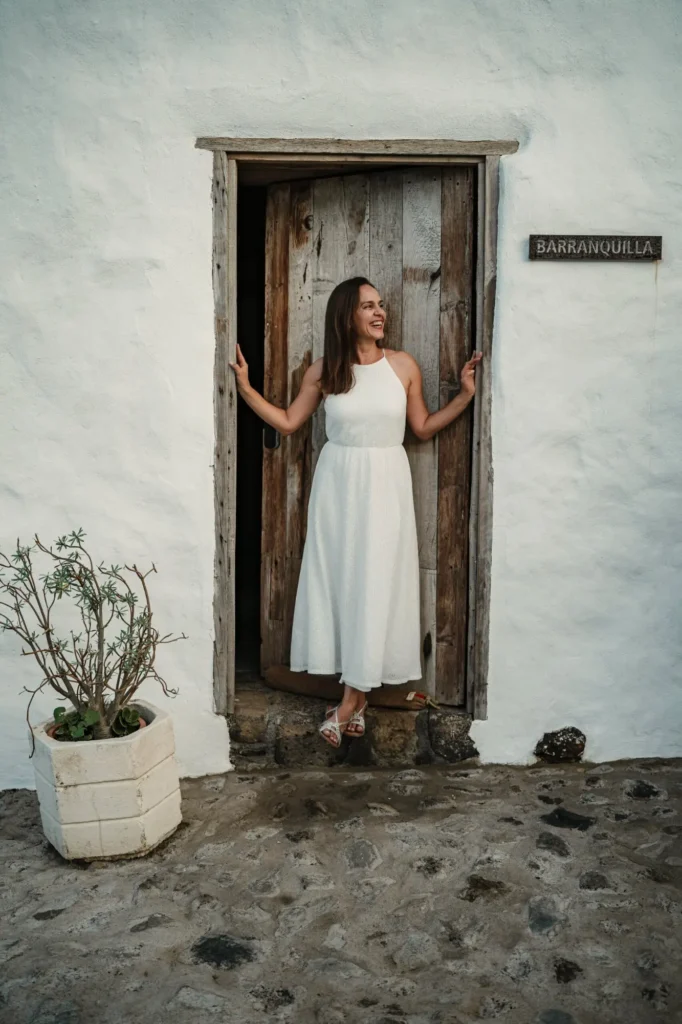 Novia durante sesión de preboda junto a puerta rústica con luz natural