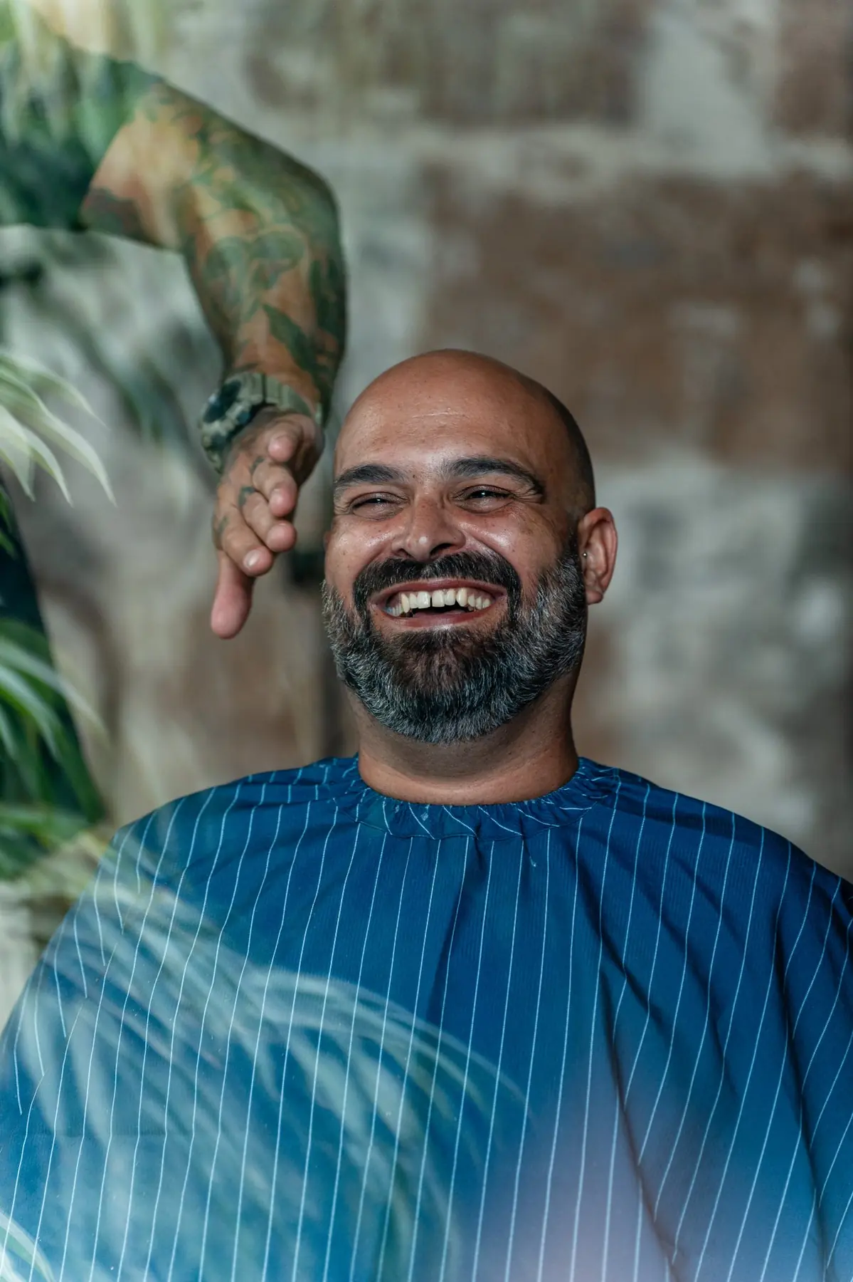 Novio sonriendo durante los preparativos con barbero en finca La Suerte Grande