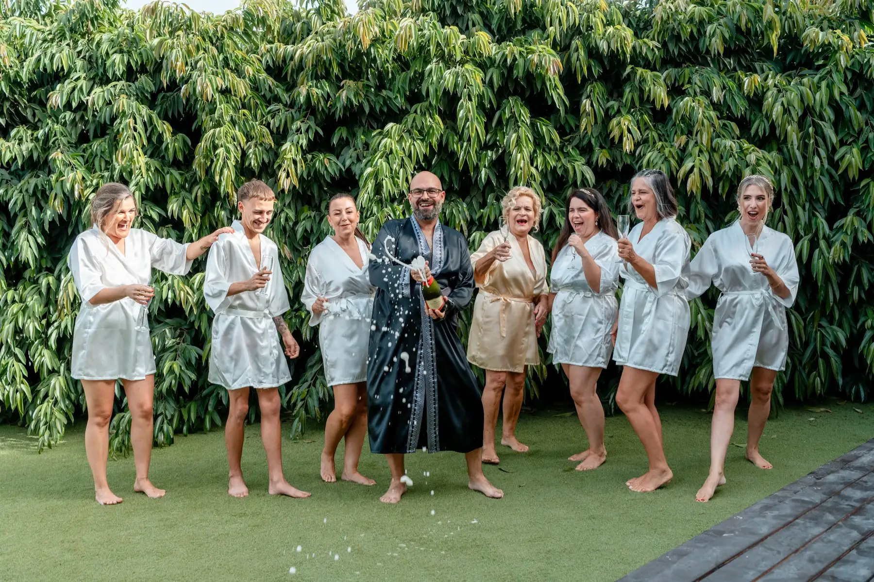 Novio descorchando champán con amigos