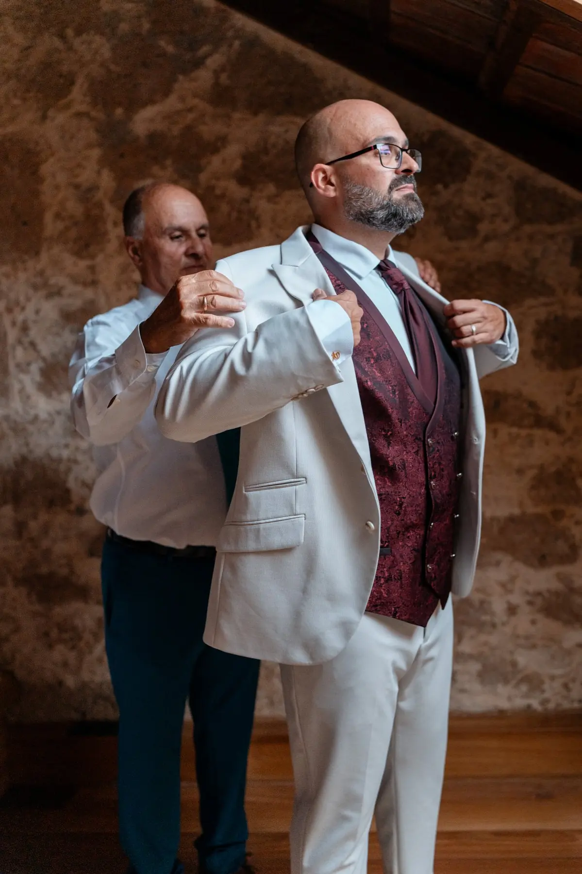 Padre ayudando al novio con la chaqueta