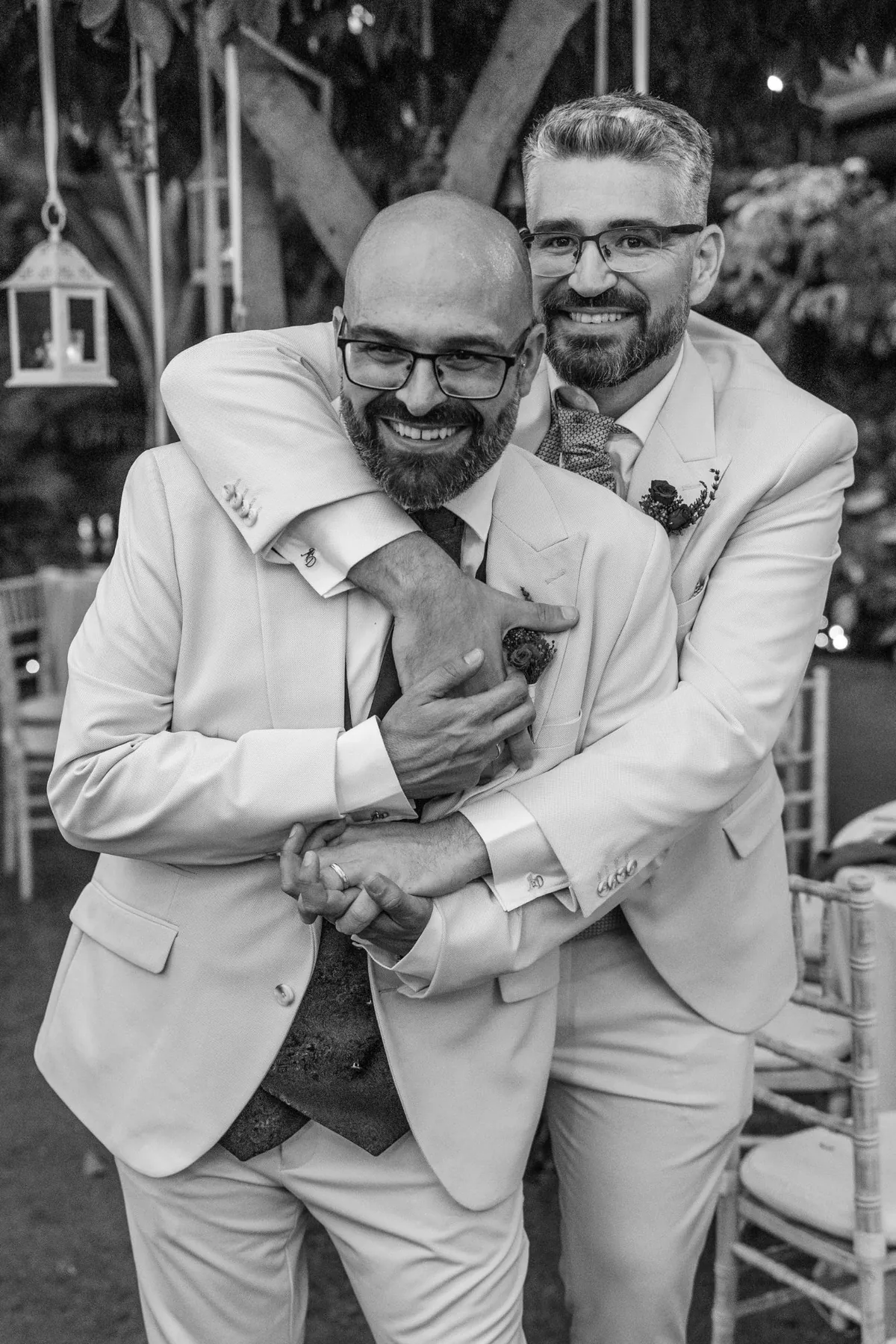 Novios abrazándose y riendo en blanco y negro