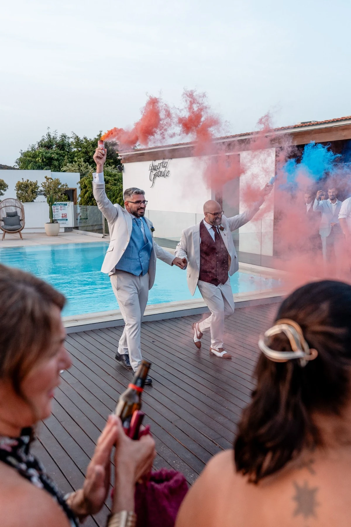 Entrada de los novios con bengalas junto a la piscina