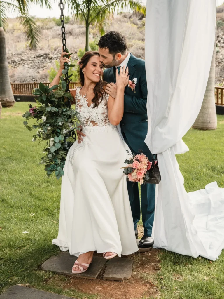 Novios en columpio rodeados de jardín tropical durante su boda en Gran Canaria