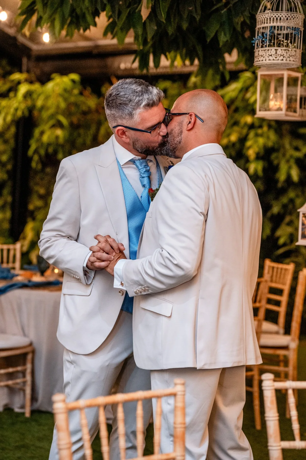 Primer beso de los novios tomados de la mano durante la ceremonia