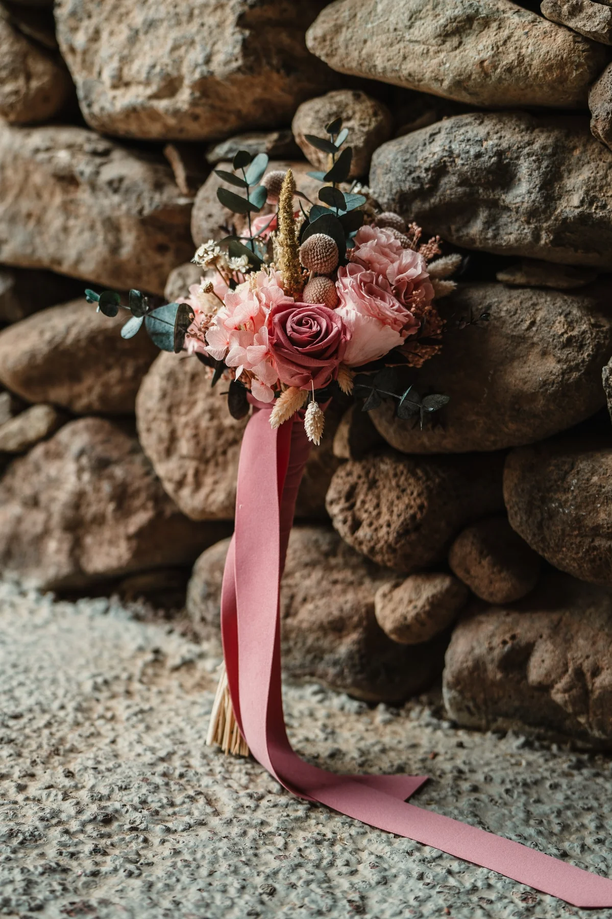 Ramo de novia con rosas sobre piedra volcánica en boda en Hacienda de Anzo, Gran Canaria
